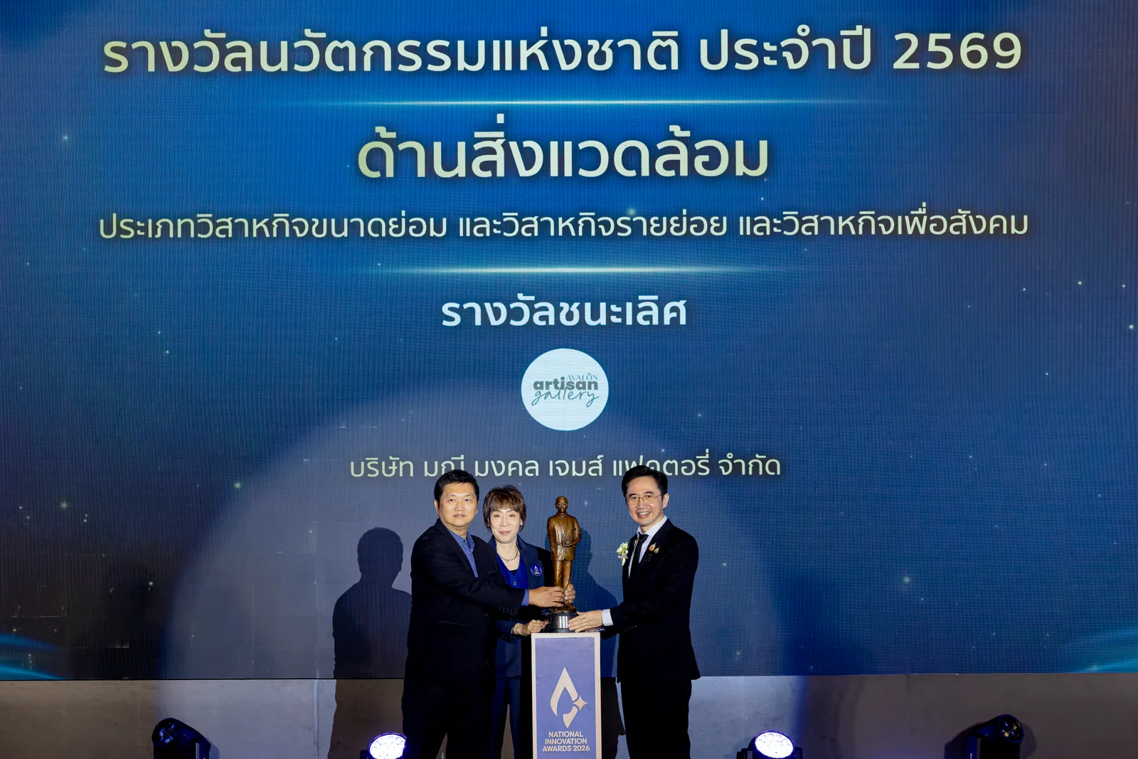 บนเวทีขณะรับรางวัล จอแสดงชื่อรางวัลด้านสิ่งแวดล้อมและชื่อบริษัท