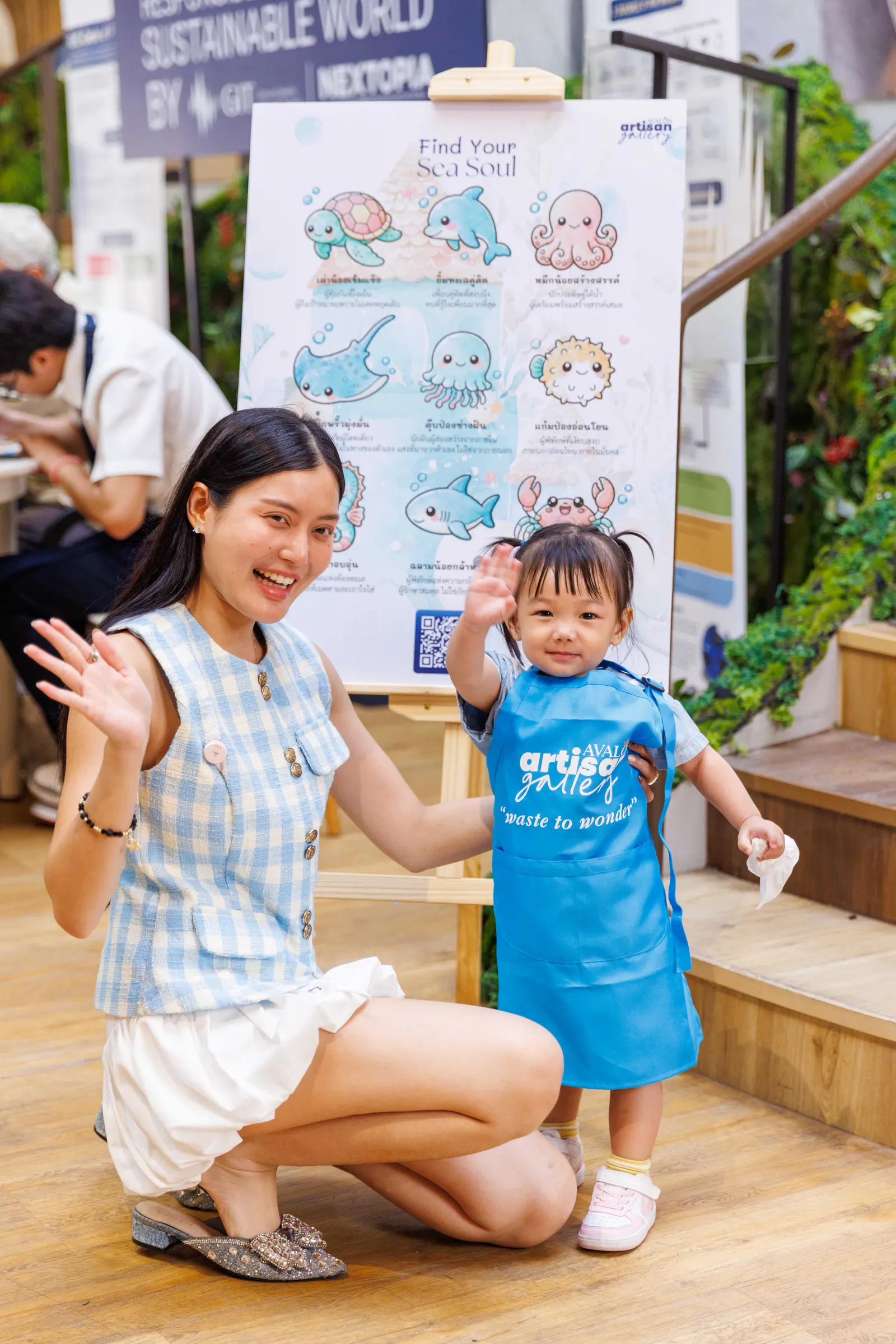 A child in an AVALON apron waves at the Find Your Sea Soul workshop